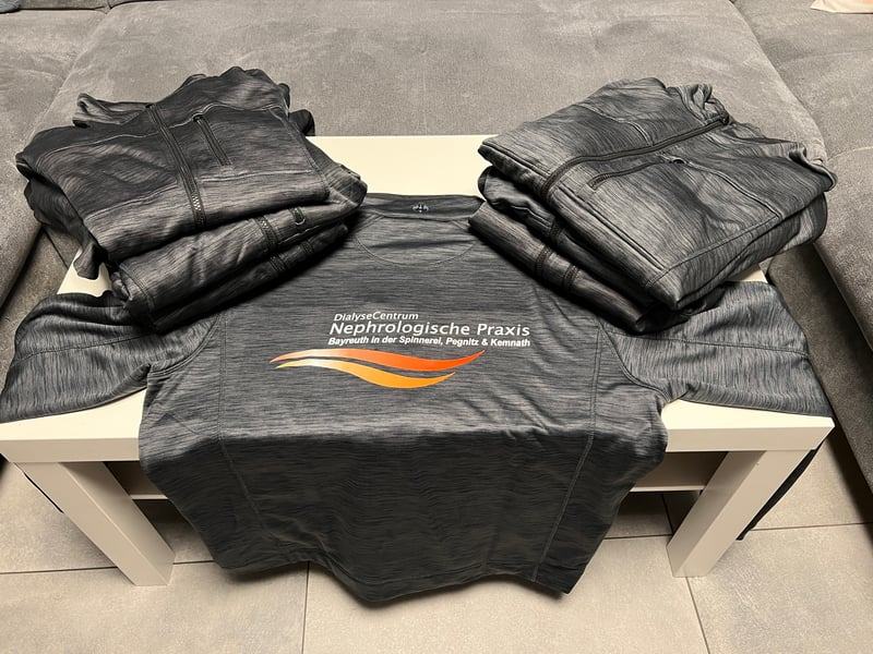 Bedruckte Textilien mit Praxis-Branding auf dem Arbeitstisch